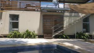 a building with a staircase next to a swimming pool at Container home 25 min Jaco y Herradura in Tarcoles