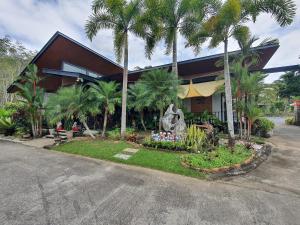 a building with palm trees in front of it at บีฮายฮิลล์ รีสอร์ต 