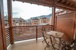 einen Balkon mit einem Tisch und Stühlen in der Unterkunft Hill-side Apartment in Nation Park in Bansko