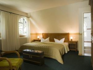 a hotel room with a bed and a suitcase at Hotel Hiddensee Hitthim in Kloster