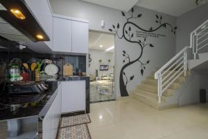 a kitchen with a tree mural on the wall at Villa Palm Springs by REQhome in Ciater-hilir