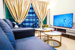 a living room with a blue couch and a television at Lovely Family Suites at Razak City Residence KL by HCK in Kuala Lumpur