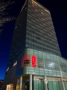 un edificio alto con una señal roja. en Atyrau Executive Apartments en Atyraū