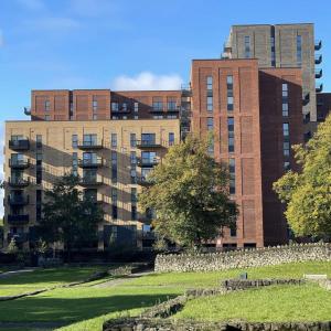 an apartment building in front of a park at Stylish Ensuite Double-Bed with Desk in Barking