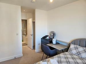 een slaapkamer met een bed, een bureau en een tafel bij Stylish Ensuite Double-Bed with Desk in Barking