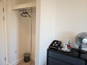 a room with a black dresser and a fan at Stylish Ensuite Double-Bed with Desk in Barking