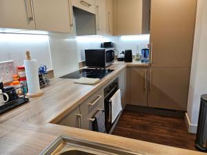 a kitchen with a stove and a microwave at Stylish Ensuite Double-Bed with Desk in Barking