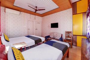 a room with two beds and a tv at OYO Hotel USA Hotel in Silchar