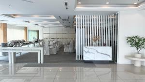 a restaurant with white tables and white walls at Legend Inn Taiping in Taiping