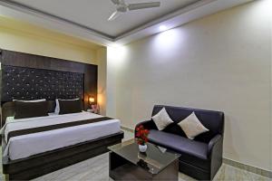 een hotelkamer met een bed en een bank bij Townhouse Hotel Refresh in Calcutta