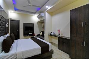 a hotel room with a bed and a tv at Townhouse Hotel Refresh in Kolkata