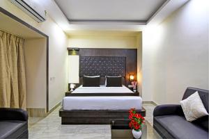 een hotelkamer met een bed en twee banken bij Townhouse Hotel Refresh in Calcutta