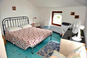 a bedroom with a bed and a window and a fan at Domus Antonina in Vietri sul Mare