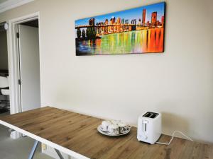 a table with a picture on the wall at Sunshine hillcrest home in Auckland