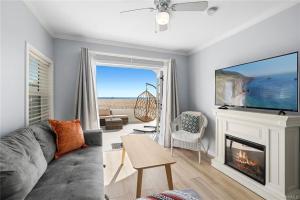 a living room with a couch and a tv and a fireplace at Oceanfront M Boutique Hotel in Lido Isle