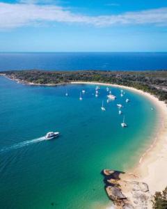 an aerial view of a beach with boats in the water at Tree Top Rest - Bright Water Retreat in Bundeena