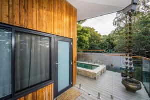 a balcony with a tub on a wooden deck at Tree Top Rest - Bright Water Retreat in Bundeena