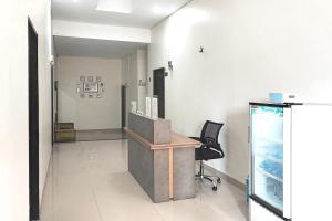 Urbanview Hotel Syariah near Polda Jambi في Palmerah: غرفة انتظار مع مكتب وكرسي