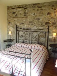 a bed in a bedroom with a stone wall at B&b Il Tulipano in Polverara