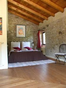 um quarto com uma cama e uma cadeira num quarto em B&b Il Tulipano em Polverara