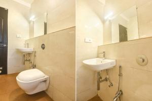 La salle de bains est pourvue de toilettes, d'un lavabo et d'un miroir. dans l'établissement FabExpress Holiday Suites, à Benaulim