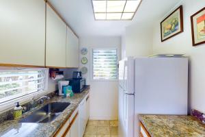 a kitchen with a white refrigerator and a sink at Kapa`a Sands 18 in Kapaa