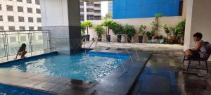 a man sitting on a chair in a swimming pool in a building at ADB AVENUE TOWER in Manila