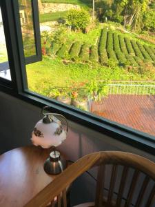 una mesa con una lámpara y una ventana con vistas a un viñedo en Bao Chi B&B en Fanlu