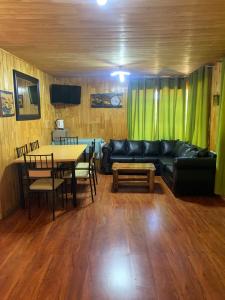 uma sala de estar com um sofá e uma mesa em Butamacho Cabaña con Tinaja x Día em Chonchi