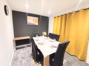 a dining room with a white table and black chairs at Sigma Lux Home in Cramlington