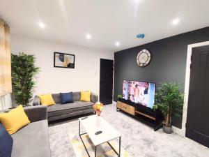 a living room with a couch and a tv at Sigma Lux Home in Cramlington