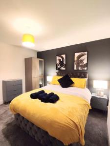 a bedroom with a large yellow bed with two lamps at Sigma Lux Home in Cramlington