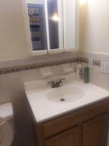 a bathroom with a white sink and a toilet at Cosy Bedroom 12mins to Airport Prudential NJIT UMDJ Penn Station in Newark