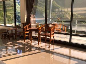 een kamer met 3 stoelen, een tafel en ramen bij Bao Chi B&B in Fanlu