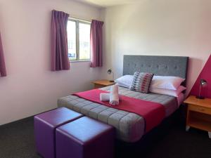 a bedroom with a bed with a red blanket at YHA Nelson in Nelson