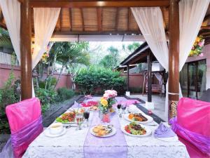 One Bedroom Private Villa Kuta في سمينياك: طاولة طويلة عليها أطباق من الطعام