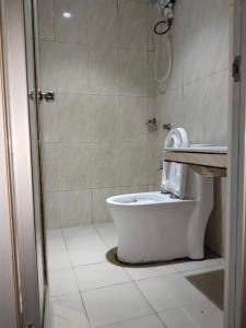 a bathroom with a shower and a toilet and a sink at Meaco Royal Hotel - Valenzuela in Subusub