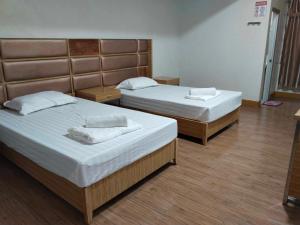 two beds in a hotel room with two bedsvisor at Meaco Royal Hotel - Valenzuela in Manila