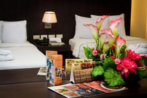 una habitación de hotel con una mesa con flores. en CityState Tower Hotel en Manila