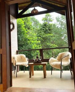 two chairs and a table on a porch with a window at Afha 48 in Monte Verde