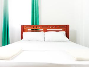 una camera da letto con un letto bianco con tende verdi di Seaside Heights 2BR 43' Smart TV a Mombasa