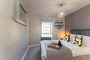 a bedroom with a bed with a tray of food on it at Elliot Oliver - Modern 2 Bedroom Town Centre Apartment in Cheltenham +12 photos
