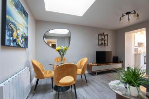 a living room with a table and chairs and a television at Elliot Oliver - Modern 2 Bedroom Town Centre Apartment in Cheltenham