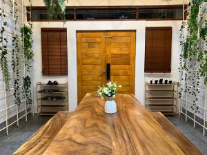 a large wooden table in a room with a door at 4 Bedroom House with Beautiful Rooftop near BTS Ekkamai in Bangkok