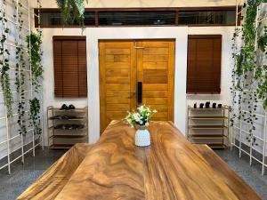 バンコクにある4 Bedroom House with Beautiful Rooftop near BTS Ekkamaiのドア付きの部屋の大きな木製テーブル