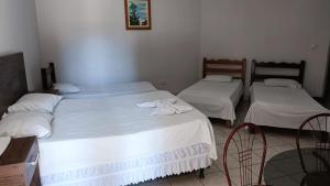 2 Betten in einem Zimmer mit weißer Bettwäsche in der Unterkunft Hotel Turazzi in Cáceres