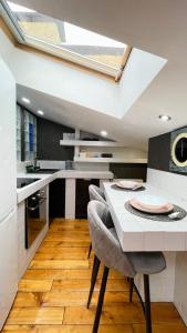 a kitchen with a table and chairs and a skylight at Сучасна світла квартира-студія in Chernivtsi