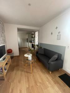 - un salon avec un canapé et une table dans l'établissement Petit maison avec terrasse proche de Rouen 1h30 de Paris, à Bihorel