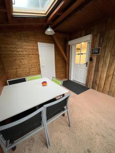a dining room with a white table and chairs at Les Gîtes de la Bergerie - Boule de Neige in Meximieux