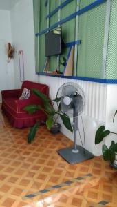 a room with a fan and a red chair at Havilah House Baguio City in Baguio